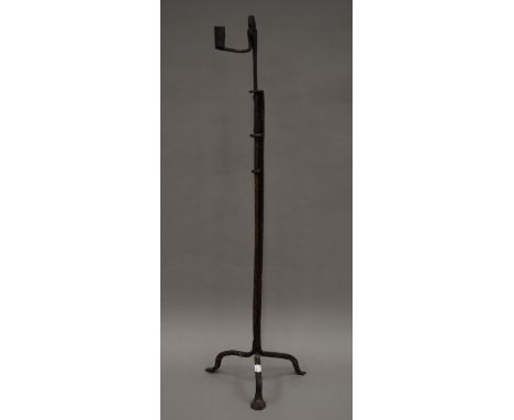 A large antique wrought iron rush light holder. 96 cm high.