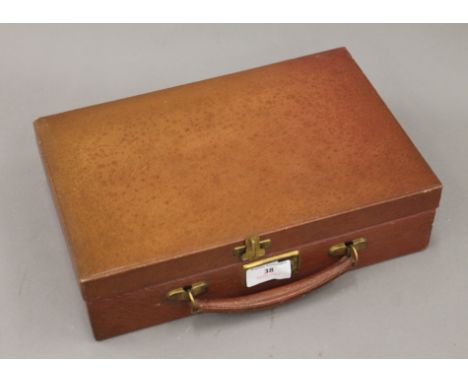 A leather writing case with inkwell, letter opener and pens. 30.5 cm wide.