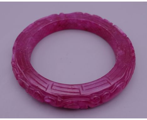 A ruby jade bangle. 5.75 cm inner diameter.