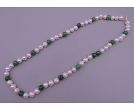 A jade and pearl necklace with a 14 ct gold clasp. 44 cm long.