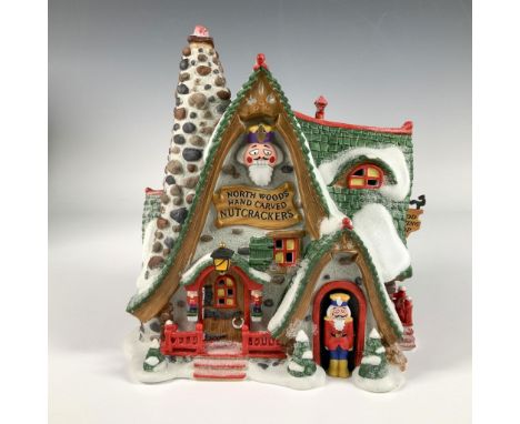 Hand painted porcelain building, the Hand Carved Nutcracker Factory features a rustic stone and wood structure with snow dust