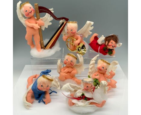 Adorable collection of figurines that includes an angel playing a harp, an angel playing a trombone, a red robed figure holdi