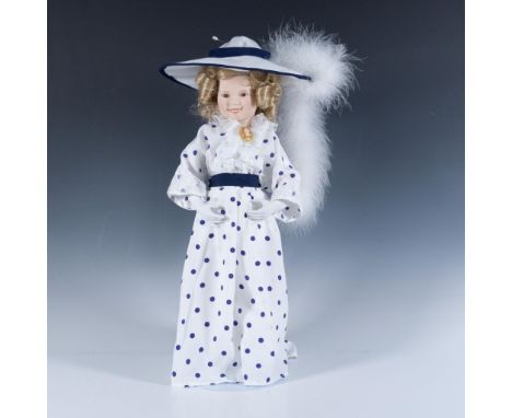 This piece features a porcelain, hand-painted face and head, dressed in a beautifully recreated costume from one of her movie