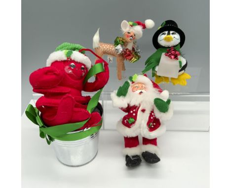 Charming collection of holiday figurines that includes a doe with presents ornament, a penguin holding a light up ice cube, a