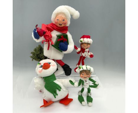 Stunning assortment of figures that includes a tall figurine with a bird house and a tree stump, a duck with a scarf and hat,