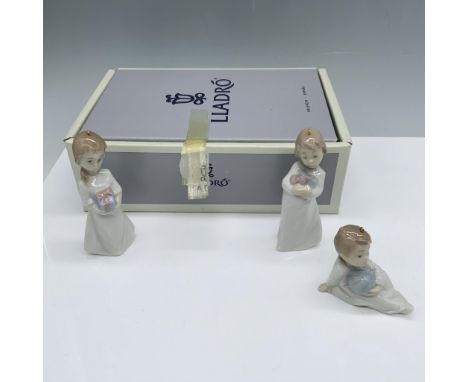 Magnificent collection of three figurines holding their Christmas presents that includes a girl with a bow, a girl with long 