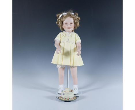 This piece features a porcelain, hand-painted face and head, dressed in a beautifully birthday party dress. Doll measures 6.5