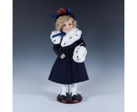 This piece features a porcelain, hand-painted face and head, dressed in a beautifully recreated costume from one of her movie