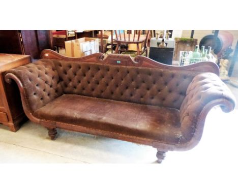 A George IV mahogany sofa with deep buttoned back and scroll arms, on reeded turned feet. 90'' wide