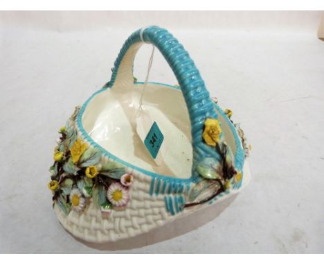 A late 19th century ceramic basket decorated with applied flowers. 7'' wide. Hair crack