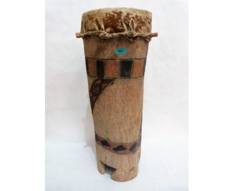 An African hollowed trunk and animal skin drum with painted and carved decoration. 29'' high