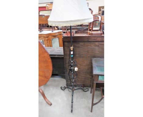 A wrought iron and brass lamp standard