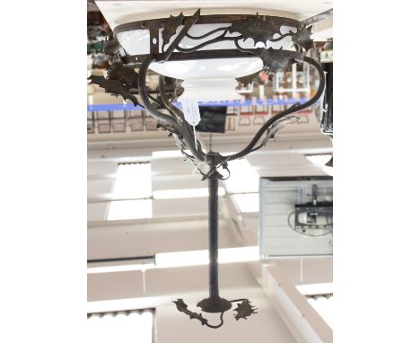 A metal pendant light in the form of holly with an opaque glass shade 