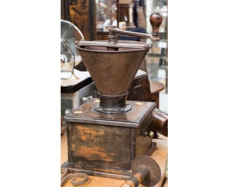 A large vintage hand operated coffee grinder on a wooden plinth 