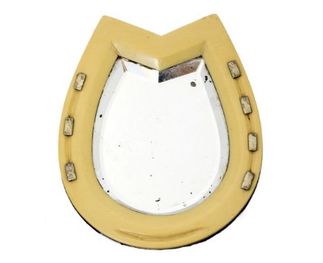 A small ivorine horseshoe shaped mirror with bevelled edge