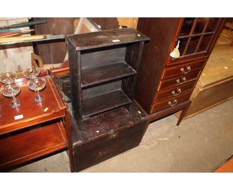 An antique wooden storage box and a carved and stained  pine open fronted bookcase and a bevel edged mirror