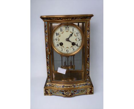 A late 19th century French 8-day mantel clock with brass and enamel detail and Arabic numerals.