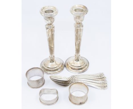 A collection of silver items to include; a pair of Elizabeth II silver candlesticks, with long thin stems and circular bases,
