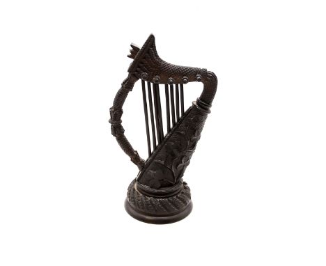 A hand-carved bog oak miniature harp, 18.5cm tall