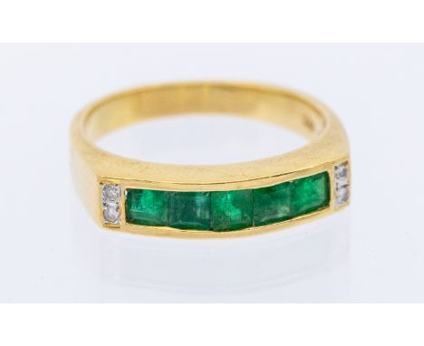 An emerald and diamond 18ct gold ring, comprising a channel et row of calibre cut emeralds, with small diamond accents to eit