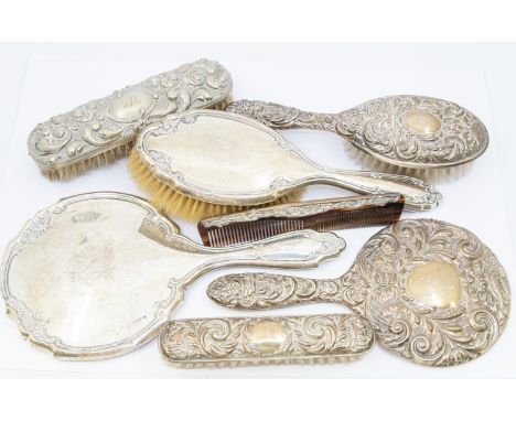 A collection of silver dressing table items to include; a matching Elizabeth II set consisting of hand mirror, clothes brush,