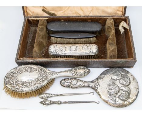 A mixed collection of silver dressing table items to include; a Birmingham silver hand mirror with elaborate Reynolds Angel's