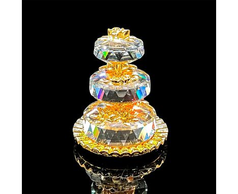 Faceted crystal figurine modeled as a three tiered wedding cake with gold tone metal flowers and cake plate. Item detaches in