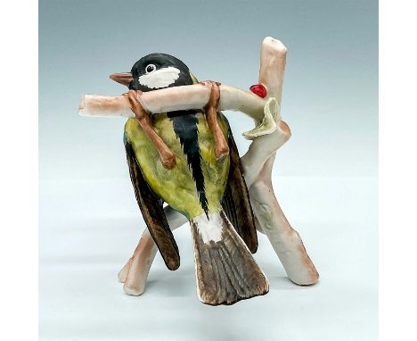 Hand painted bird with green, blue and black. The bird is seen hanging on a branch and resting ontop of another one. Goebel b