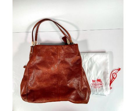 Chestnut bag has 2 side storage sections with center zippered closure. Coach carriage metal and leather tag attached to side 