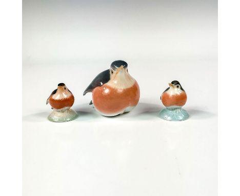 One bigger figurine with glossy finish. Modeled as a robin sitting. Grey and dusty rose coloring. Two smaller precious hand p