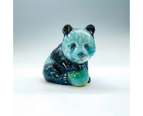 A ceramic figurine of a panda in blue glaze that is sitting on all four legs holding a toy balls. Beswick backstamp. Dimensio