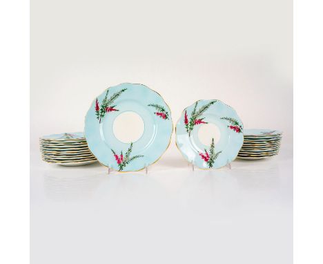 Bone china plates decorated with pink and yellow floral plants on blue ground with gilded scalloped edge. Include 12 bread an