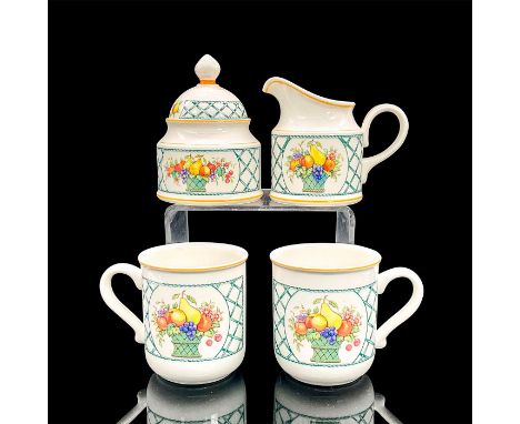 Porcelain lidded sugar bowl, creamer pitcher and two mugs in a vibrant green crisscross pattern with a basket of fruit in the