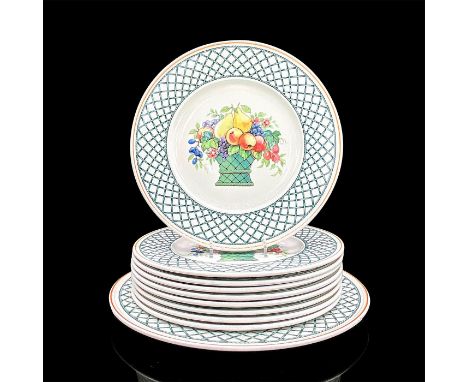 Nine porcelain plates and one serving platter in a vibrant green crisscross pattern with a basket of fruit in the center. Din