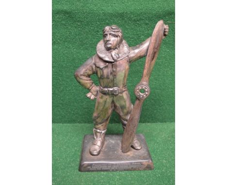 Silvered metal table lighter in the form of a pilot wearing full aviation attire including helmet and holding propeller in le