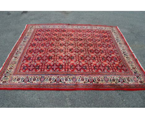 Red ground Persian Sarouk Mahal carpet having central panel decorated with blue, orange and black floral pattern and cream gr