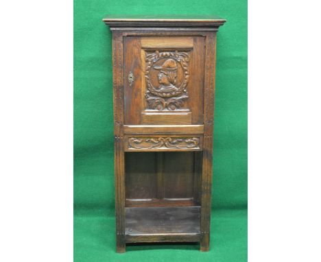 Oak carved cupboard on stand having single carved panelled door opening to reveal single fixed shelf over single carved drawe