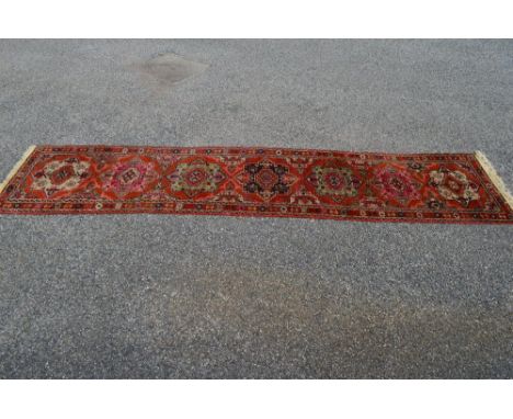 Rust ground carpet runner having pink, purple and grey patterning with end tassels - 132" x 31"