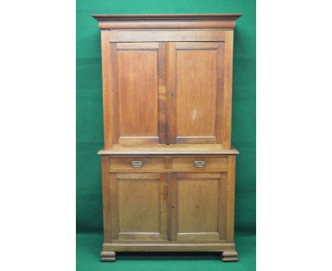 Oak cupboard having moulded cornice and two upper panelled doors enclosing two fixed shelves over two short drawers with bras