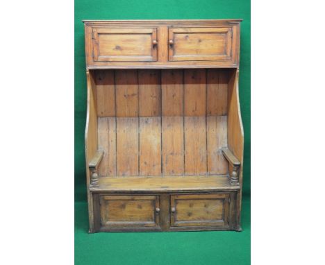 19th century pine bacon cupboard having two upper doors opening to reveal single fixed shelves over a settle bench with two f