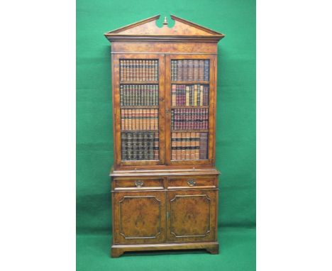 Walnut bookcase having two doors simulated as four shelves of leather bound books opening to reveal three adjustable shelves 