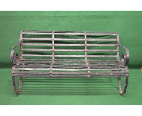 Victorian wrought iron garden bench having iron slatted back and seat with scrolled front edge, supported on a scrolled frame