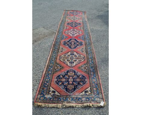 Red ground carpet runner having blue, red and cream pattern with end tassels - 179" x 34"