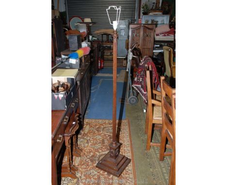 A reproduction Oak Standard Lamp having carved top, on turned and reeded column, on architectural square base
