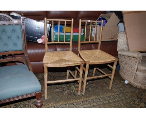 A pair of Arts and Crafts Beech and Ash stick back, rush seated Bedroom Chairs, on turned legs with stretchers, probably Morr