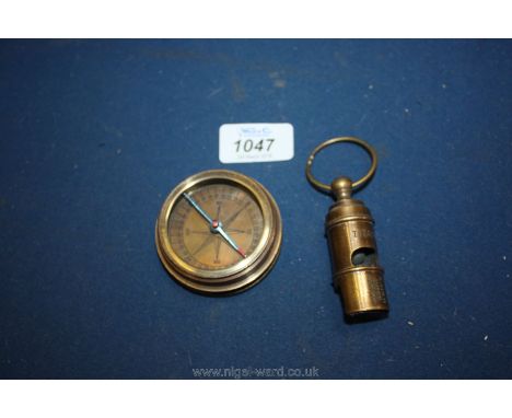 Two pieces of Titanic memorabilia: a screw top compass and a White Star whistle.