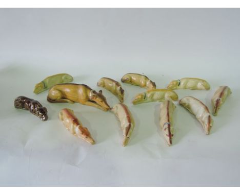 A collection of late 19th century ceramic models of recumbent greyhounds including larger example with gilded collar (12)