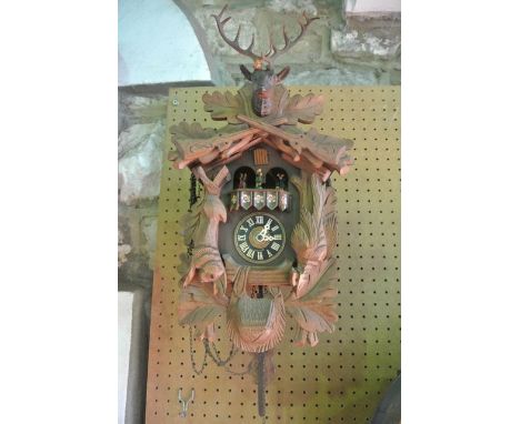 A traditional Tyrolean cuckoo clock of chalet form with applied hanging game detail, 8 day movement and painted character det