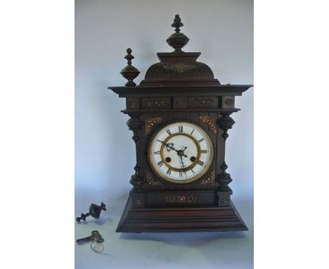 A late 19th century German mantle clock, the timber case with applied brass detail enclosing an eight day striking movement