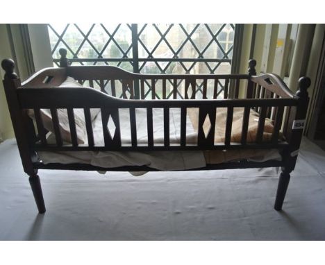 A good quality miniature oak single bed with slatted panelled sides and simple kite cut pierced detail, raised on four slende